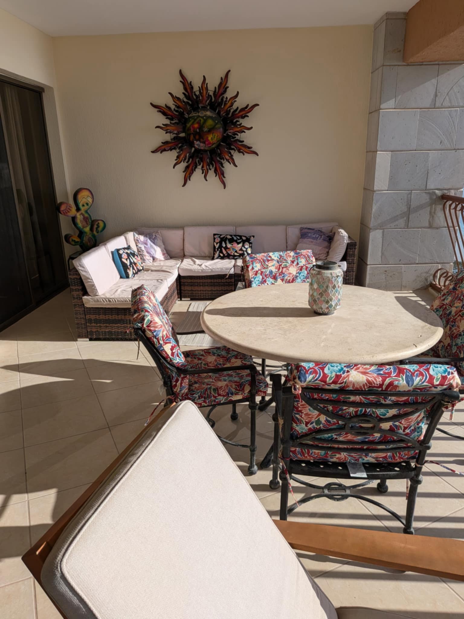 Private balcony seating and dining furniture with colorful sun wall art