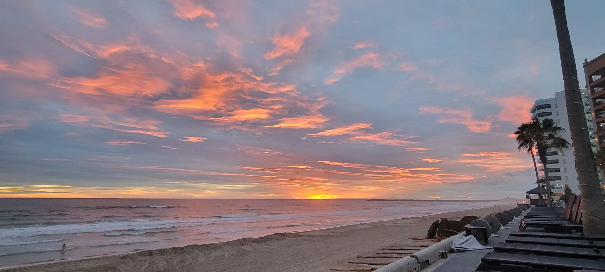 Pink clouds stretching over the Sea of Cortez and the beachfront